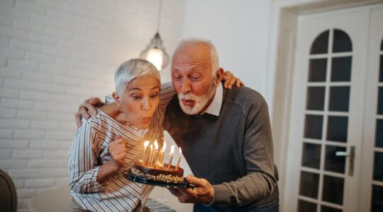 Older couple blowing out birthday candles. | Newsreel