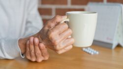 Person holding hand steady with coffee cup. | Newsreel