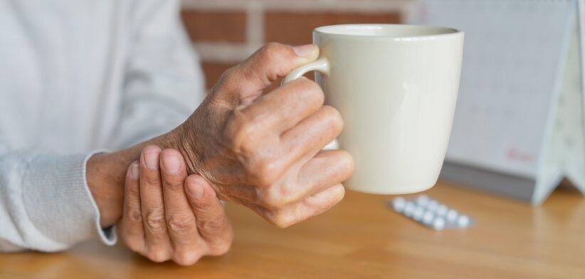 Person holding hand steady with coffee cup. | Newsreel