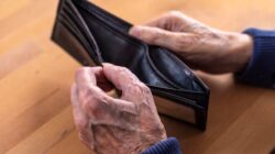 Aged man looking at empty wallet. | Newsreel