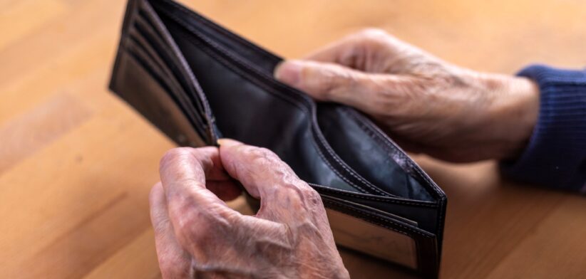 Aged man looking at empty wallet. | Newsreel