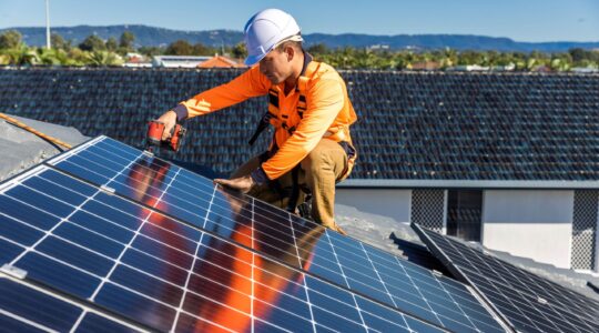 Worker installing roof-top solar. | Newsreel