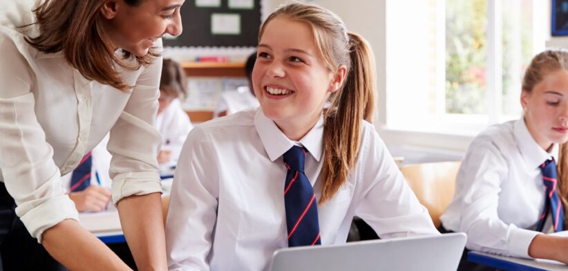 Teacher with student in classroom. | Newsreel