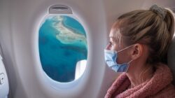 Woman on plane wearing mask. | Newsreel