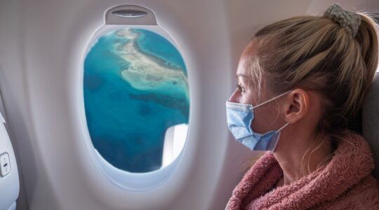 Woman on plane wearing mask. | Newsreel