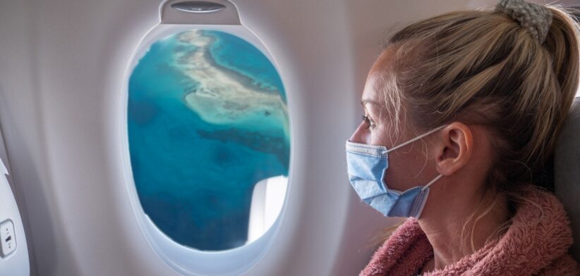 Woman on plane wearing mask. | Newsreel