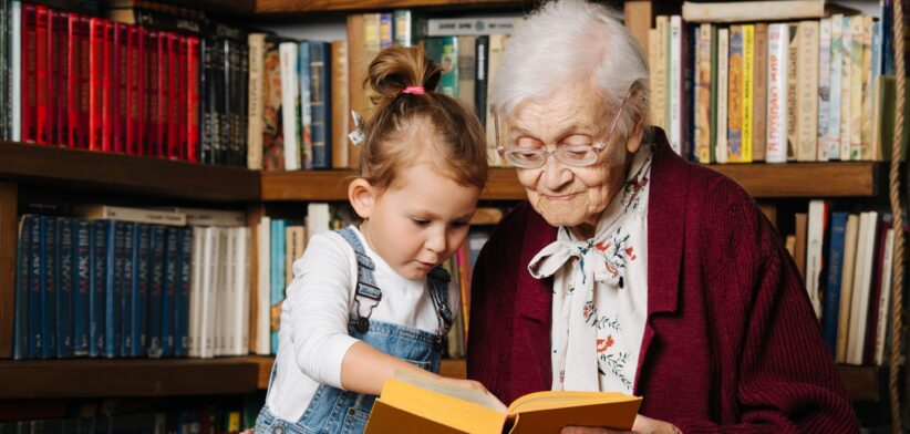 Young and old person reading a book. | Newsreel