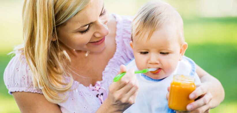 Woman feeding baby from a jar. | Newsreel