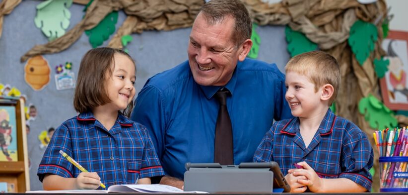 All Saints School principal Robert Campbell with students. | Newsreel