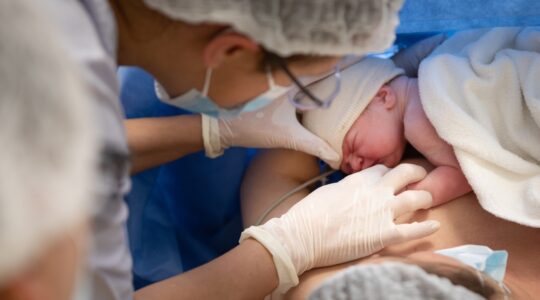 Nurse helps baby breastfeed in hospital. | Newsreel