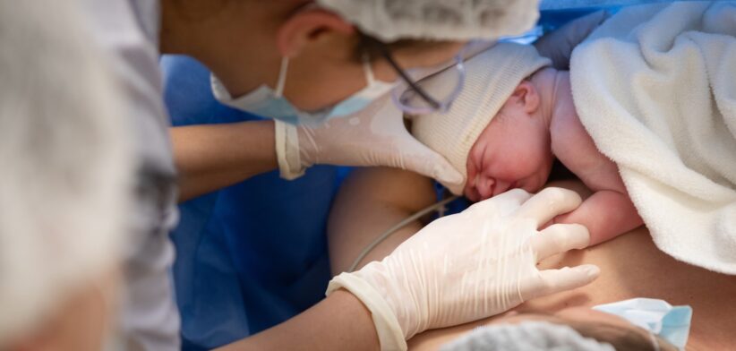 Nurse helps baby breastfeed in hospital. | Newsreel