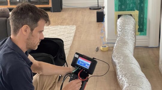 CSIRO researcher conducting a home air tightness test. | Newsreel