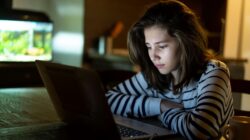 Worried child looking at computer. | Newsreel