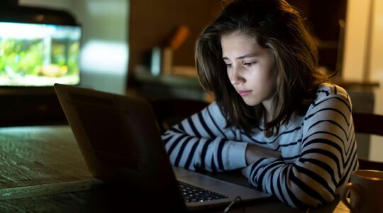 Worried child looking at computer. | Newsreel