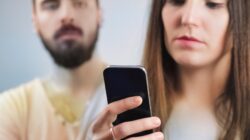 Man looking at woman on phone. | Newsreel