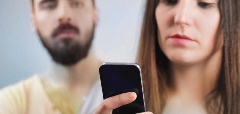 Man looking at woman on phone. | Newsreel