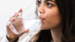 Woman drinking water out of glass. | Newsreel