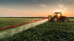 Farmer spraying on tractor. | Newsreel