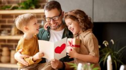 Dad looking at Father's Day card with children. | Newsreel