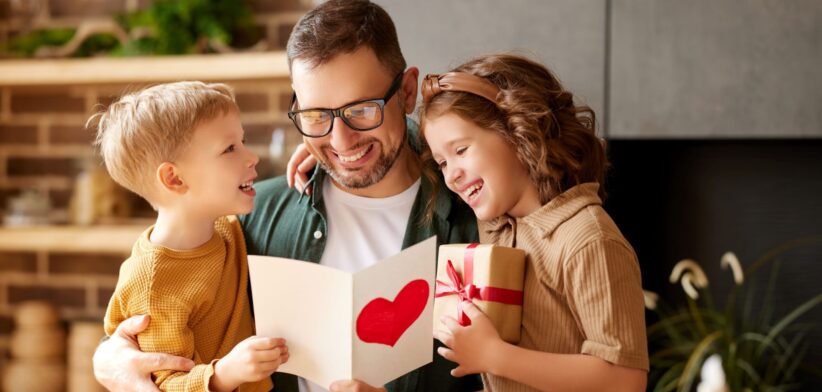 Dad looking at Father's Day card with children. | Newsreel