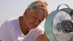 Heat stressed elderly woman in front of fan. | Newsreel