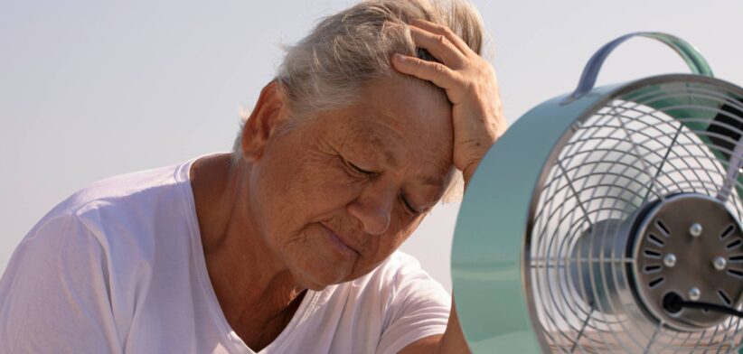 Heat stressed elderly woman in front of fan. | Newsreel