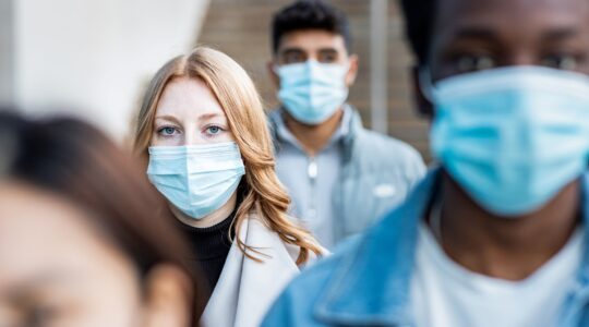 Woman in crowd wearing mask. | Newsreel