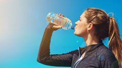 Woman drinking from plastic water bottle. | Newsreel