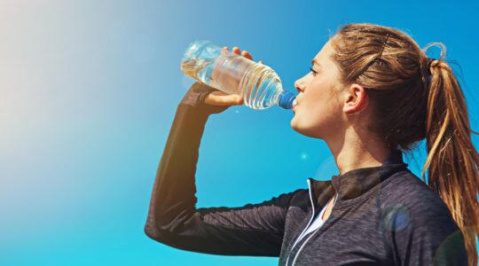 Woman drinking from plastic water bottle. | Newsreel