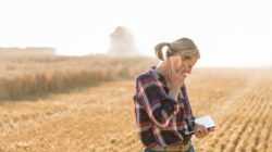 Woman on a farm with phone and tablet computer. | Newsreel