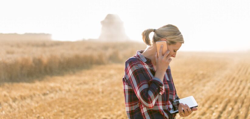 Woman on a farm with phone and tablet computer. | Newsreel