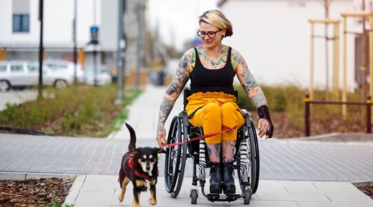 Woman in wheelchair taking dog for a walk. | Newsreel