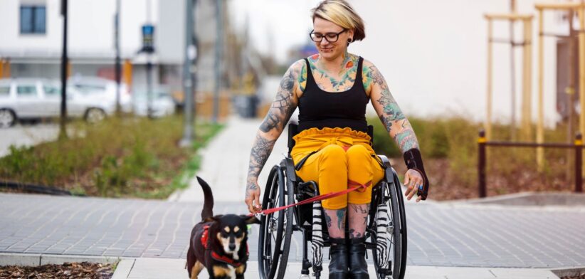 Woman in wheelchair taking dog for a walk. | Newsreel