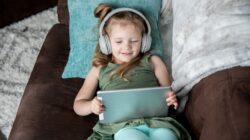 Child watching content on tablet with headphones.