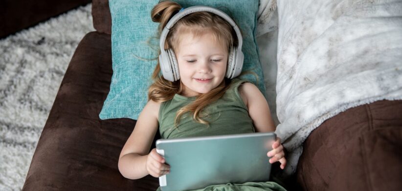 Child watching content on tablet with headphones.