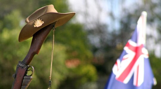 Anzac slouch hat on rifle with Australian flag. | Newsreel