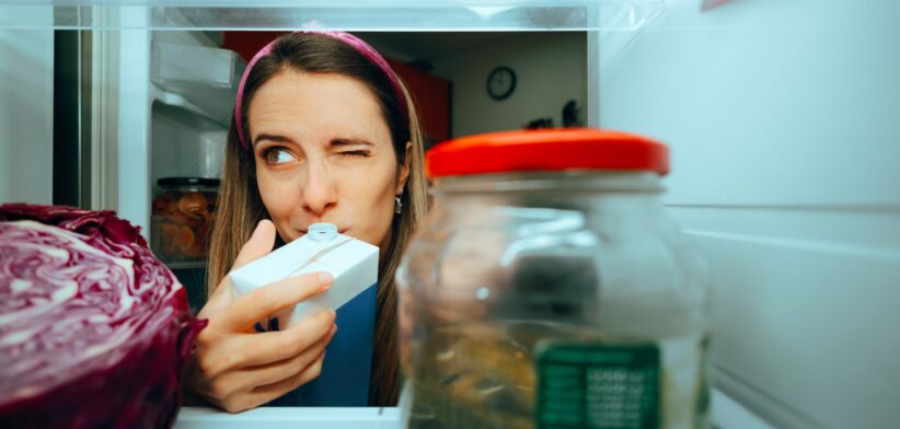 Woman testing milk in fridge. | Newsreel