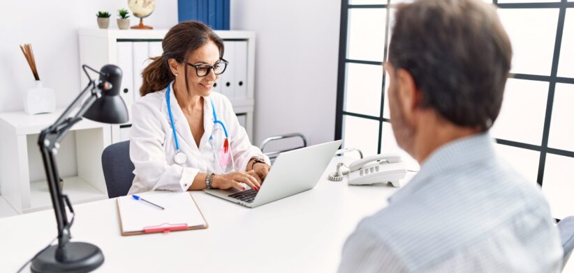 Doctor in consultation with patient taking notes. | Newsreel