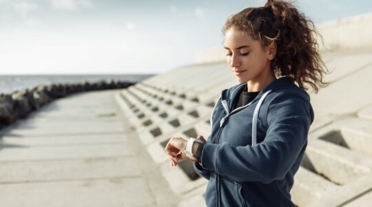 Woman checking wearable activity tracker. | Newsreel