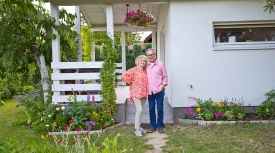 Elderly couple outside home. | Newsreel