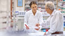 Pharmacist talking to elderly man in chemist. | Newsreel