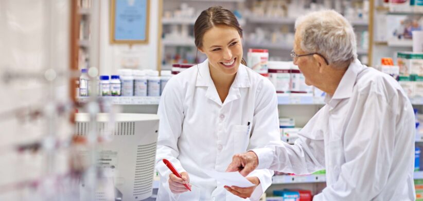 Pharmacist talking to elderly man in chemist. | Newsreel