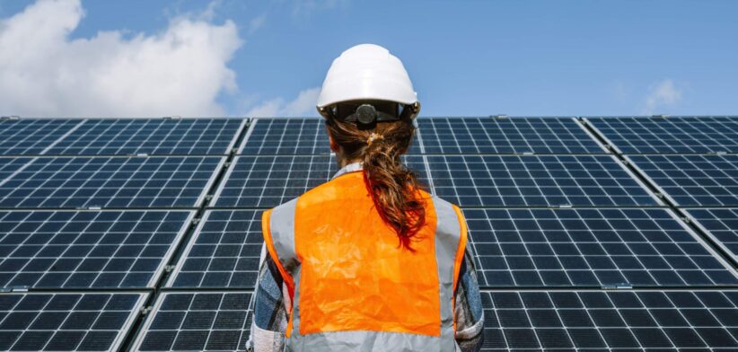 Worker looking at solar panels. | Newsreel