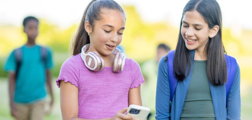 Teenagers looking at mobile phone. | Newsreel