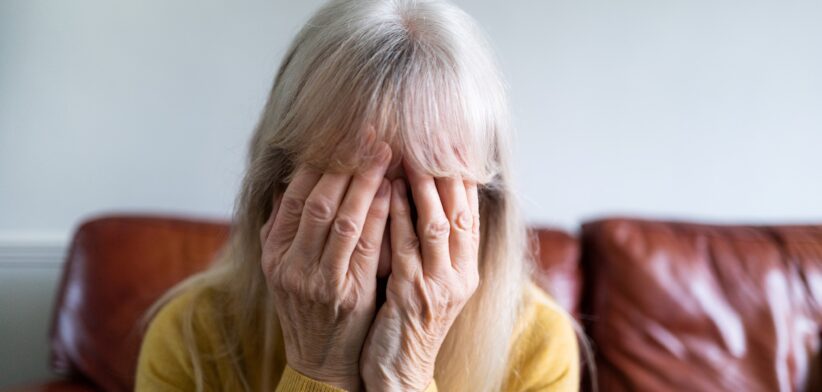 Elderly woman with head in hands. | Newsreel