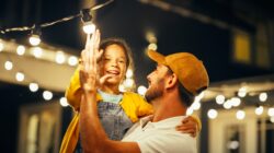 Father and child with fairy lights. | Newsreel