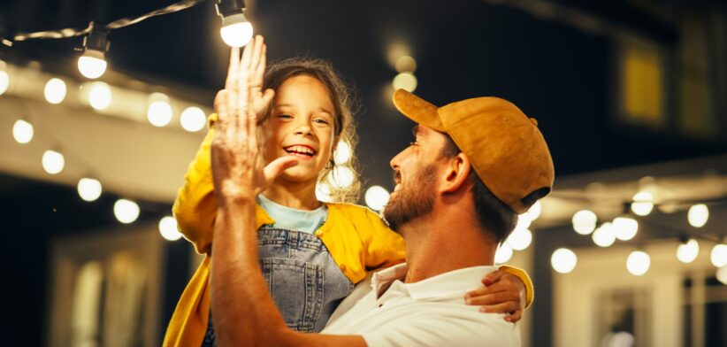 Father and child with fairy lights. | Newsreel