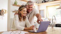 Happy couple looking at computer. | Newsreel