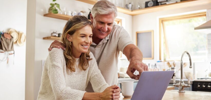 Happy couple looking at computer. | Newsreel