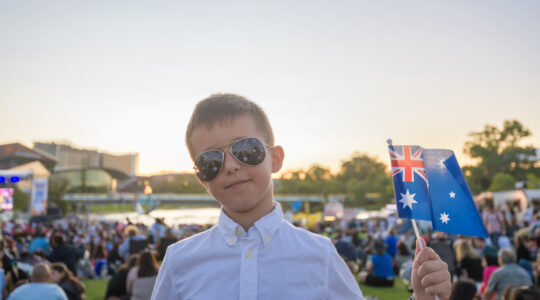 Australian kid holding a flag while celebrating Australia day